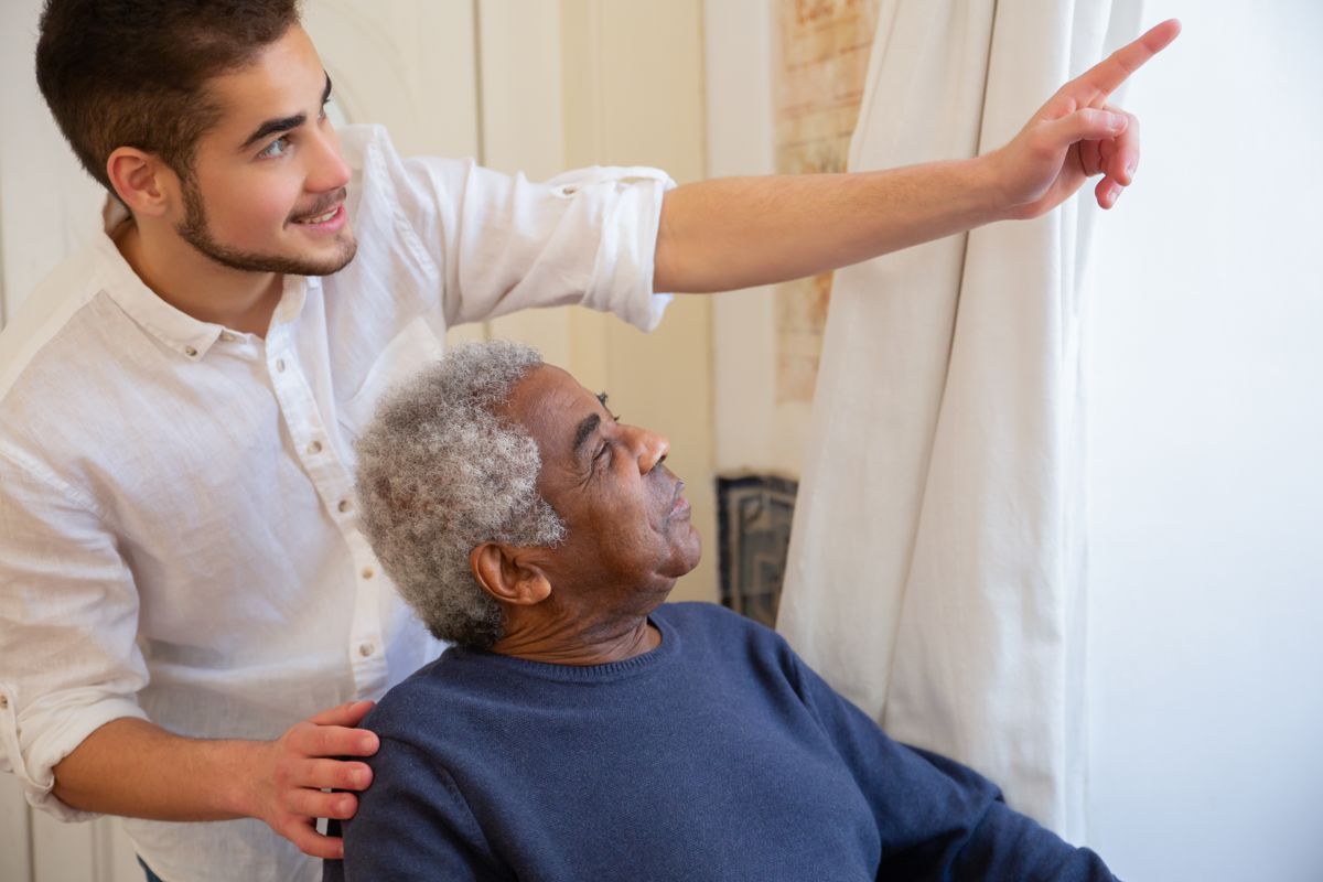 A companion helping an older man with gentle movement