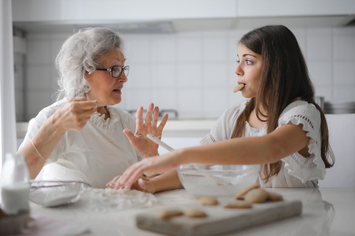 An older woman baking with a younger relative